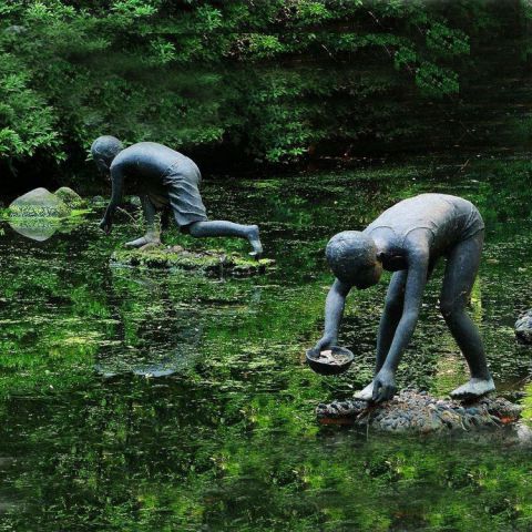 在水里干活的兒童銅雕